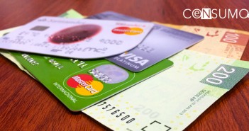 Fotografía de diferentes tarjetas de crédito con billetes de cien y doscientos pesos