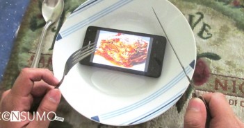dispositivo movil en un plato con imagen de comida en la pantalla