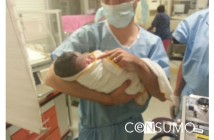 Fotografía enfermero cargando recien nacido en una sala de parto