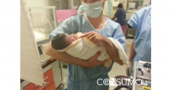 Fotografía enfermero cargando recien nacido en una sala de parto